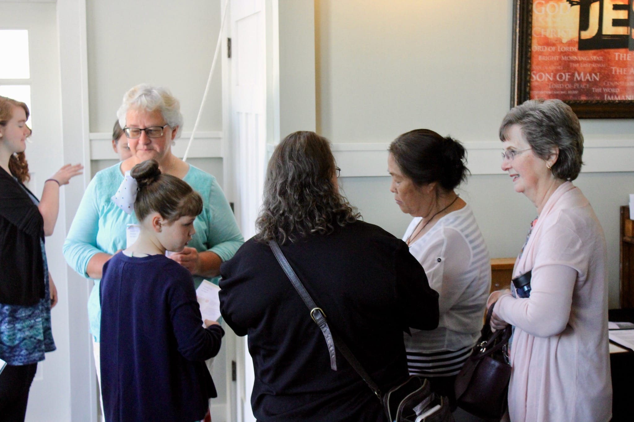 People talking around the welcome table before a Sunday service